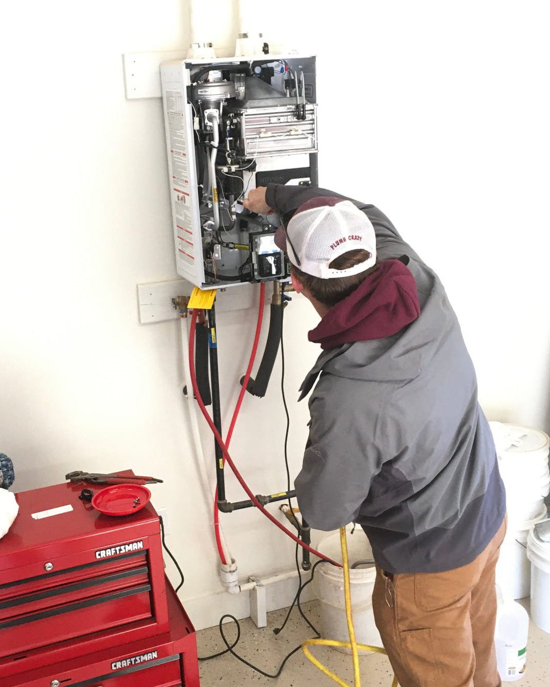 Ohmstead Plumbing technician installing a stacked outdoor tankless water heater system in Shelby NC