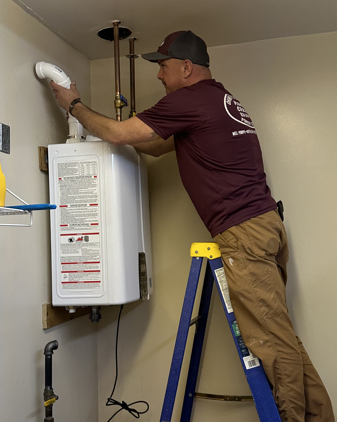 Ohmstead Plumbing technician installing a row of commercial Rinnai tankless water heaters in Forest City NC