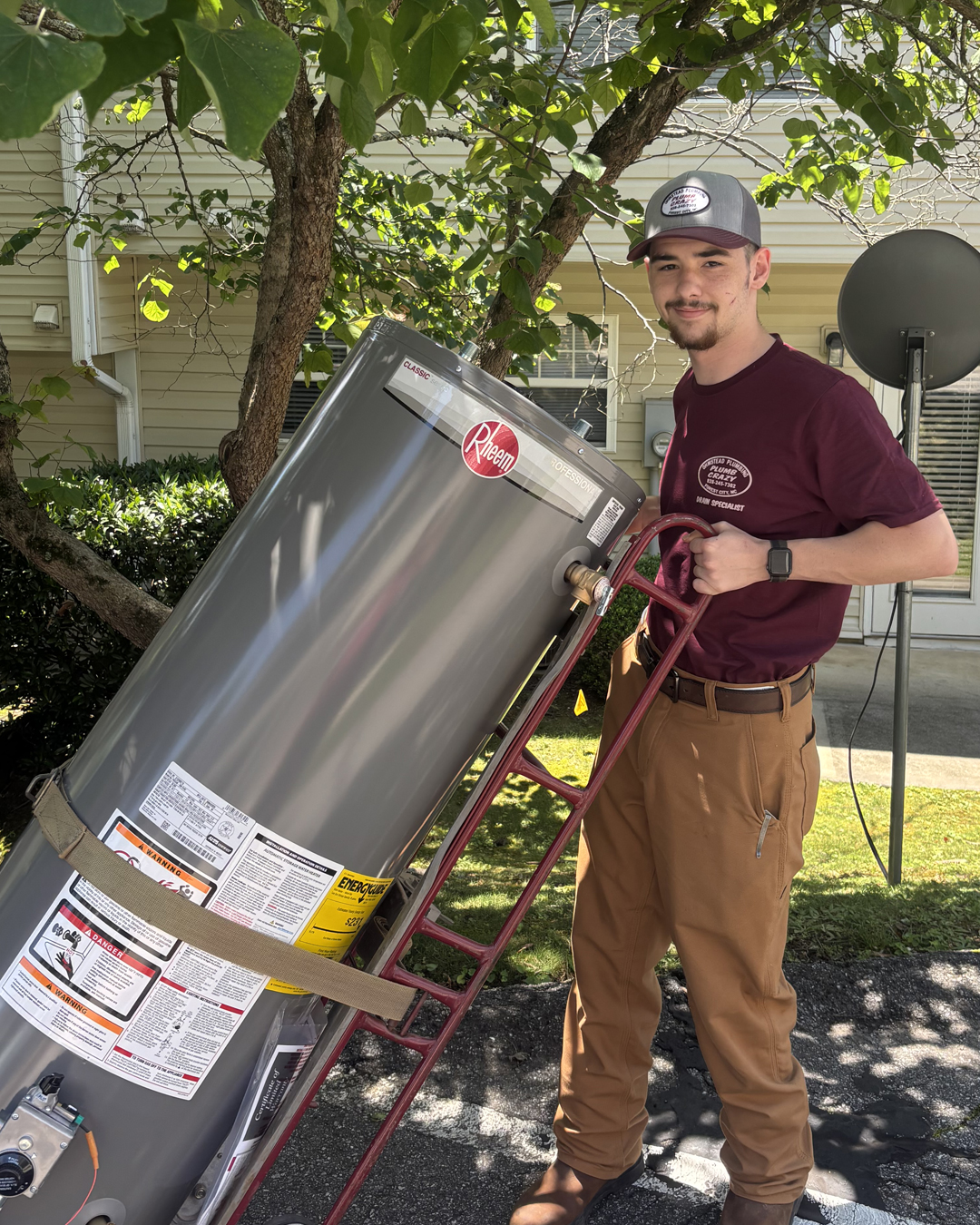 Ohmstead Plumbing technician repairing a tankless water heater blower motor inside a Shelby NC home